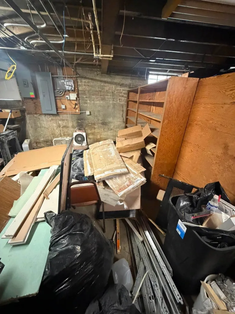 Before basement junk removal in Green Bay – messy basement packed with unwanted items and clutter