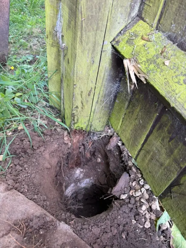 Before fence post repair in Green Bay – leaning wood fence post caused by frost heave