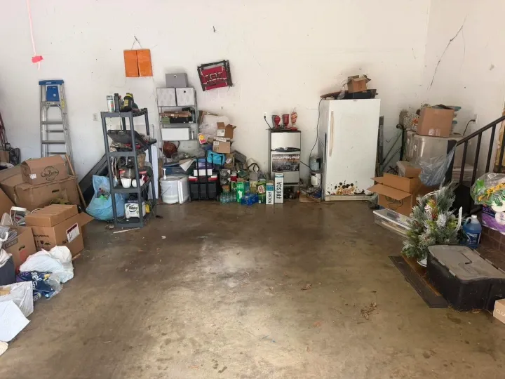 Before garage junk removal in Green Bay – cluttered garage filled with old furniture and boxes
