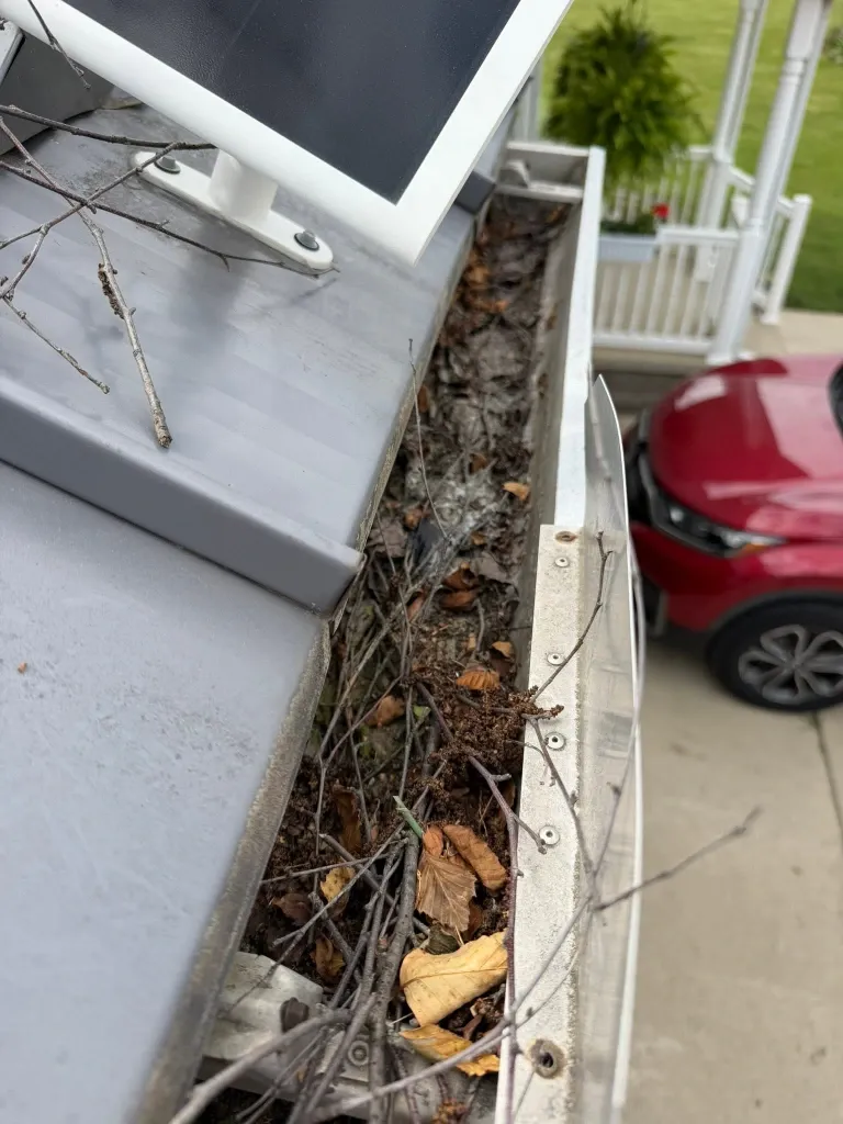 Before gutter downspout cleaning in Green Bay – completely blocked downspout preventing water drainage