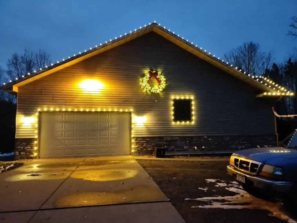 After holiday porch light installation in Green Bay – front porch and entryway lit with warm holiday lights
